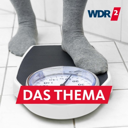 Füße in Socken, die auf eine Personenwaage auf dem gefliesten Badezimmerboden treten, um das Körpergewicht zu messen