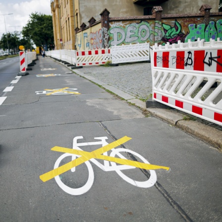 Das Piktogramm für einen neuen Radweg in der Ollenhauerstraße in Berlin-Reinickendorf wurde mit einer gelben Markierung durchkreuzt (Bild: dpa / Thomas Trutschel)