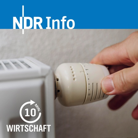 Ein Mann dreht am Thermostat einer Heizung