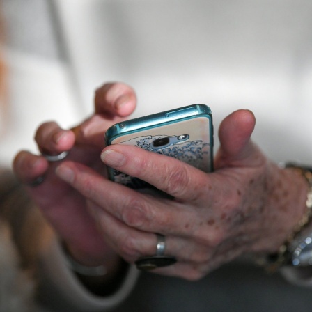 Seniorin hält ein Smartphone