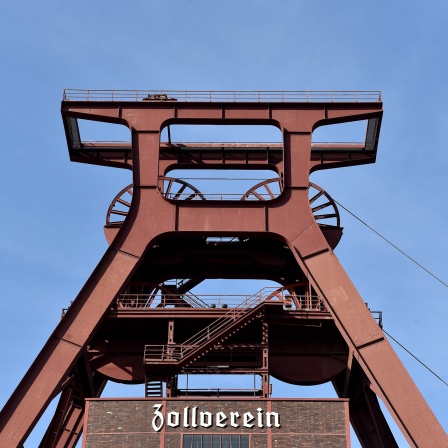 Blauer Himmel ist hinter dem Förderturm der Zeche Zollverein zu sehen. 