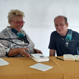 NDR Redakteurin Anke Jahns und Peter Wawerzinek sitzen lächelnd an einem Tisch mit Büchern und Mikrofonen.