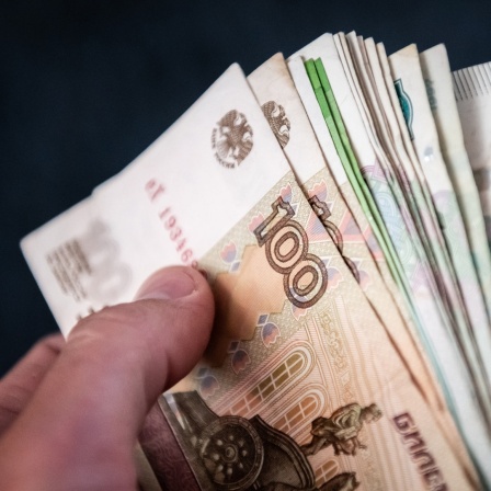 Ein Mann hält Rubelscheine in der Hand