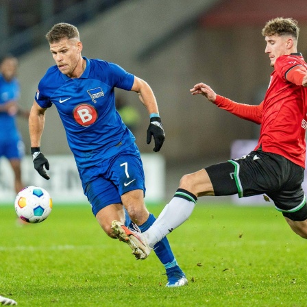 Herthas Florian Niederlechner (m.) versucht sich gegen zwei Hannoveraner durchzusetzen.