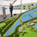 Ein Mann steht neben einem Modell eines Solarparks.