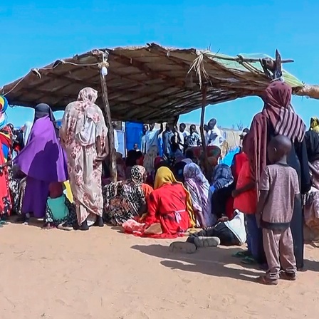 Sudanesische Flüchtlinge versammeln sich vor einem Feldlazarett. 