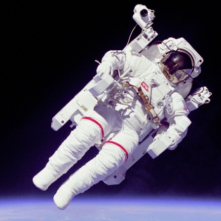 Ein Astronaut schwebt im Weltall, hinter ihm die blaue Erde und der schwarze Himmel.
