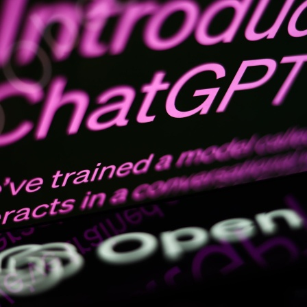 Die ChatGPT-Website ist auf dem Bildschirm eines Laptops und das OpenAI-Logo auf dem Bildschirm eines Telefons zusehen.