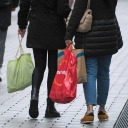 Menschen tragen Einkaufstaschen durch eine Fußgängerzone