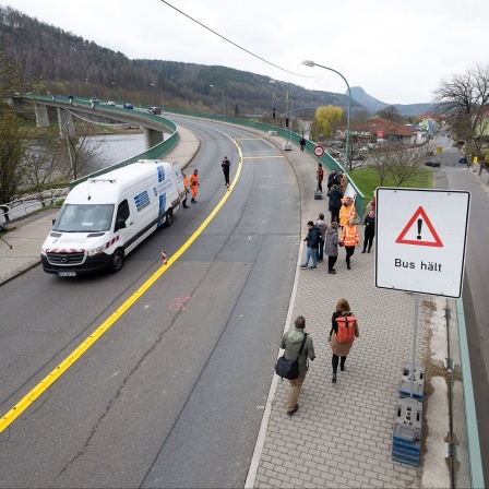 Passanten und Autos queren anlässlich der Verkehrsfreigabe die Elbbrücke in Bad Schandau.