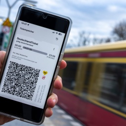 Auf dem Display eines Smartphones wird der QR-Code vom Deutschland-Ticket neben den Logos von VBB und BVG angezeigt