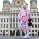 Ein Darsteller des Musikers Leopold Mozart steht in Augsburg vor dem historischen Rathaus.