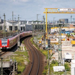 Ein Regionalzug fährt an einer Baustelle in München vorbei.