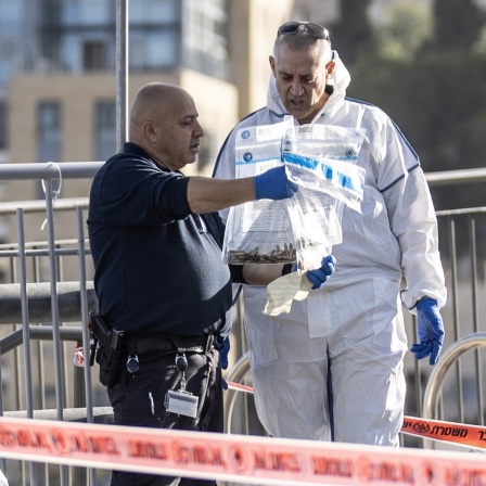 Ermittler der Polizei untersuchen Gegenstände am Tatort nach einem Anschlag in Israel. 