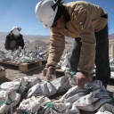 Arbeiter in einer Lithium Miene in Argentinien (Lithium Americas Corp.) mit vollen Säcken vor sich auf dem Boden. 