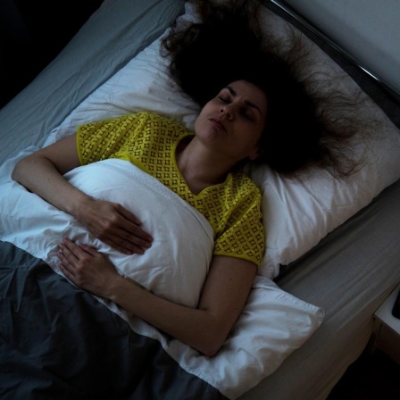 Eine Frau liegt in einem Bett und schläft 