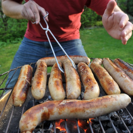 In der Nähe von Hecke und Bäumen wird gegrillt