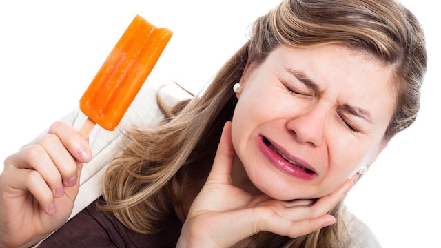 Frau mit überempfindlichen Zähnen isst Eis