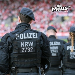 Ein Polizist in Uniform im Stadion von hinten