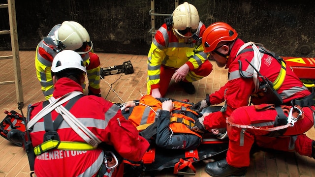 Eine Gruppe Rettungssanitäter untersucht eine Person.