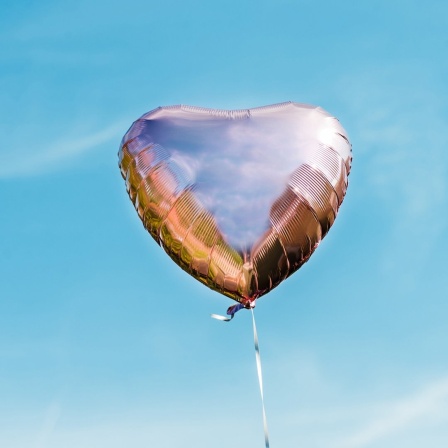 Ein silberner Luftballon in Herzform.
