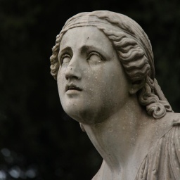 Eine leidende weibliche Steinfigur auf einem Friedhof.