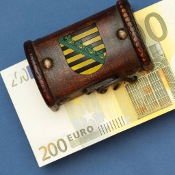 Bündel 200 Euro Geldscheine liegen in einer Schatztruhe mit Landeswappen des Flächenlands Sachsen
