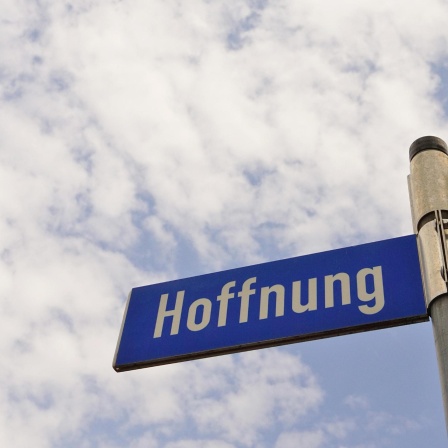 Auf einem Straßenschild ist gegen den Himmel fotografiert "Hoffnung" zu lesen.