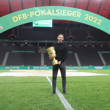 Leipzigs Trainer Domenico Tedesco mit dem DFB-Pokal im scheinbar leeren Berliner Olympiastadion.