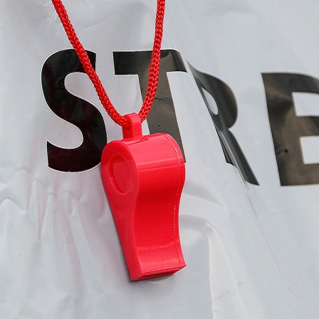 Ein Demonstrant trägt eine Trillerpfeife um den Hals.