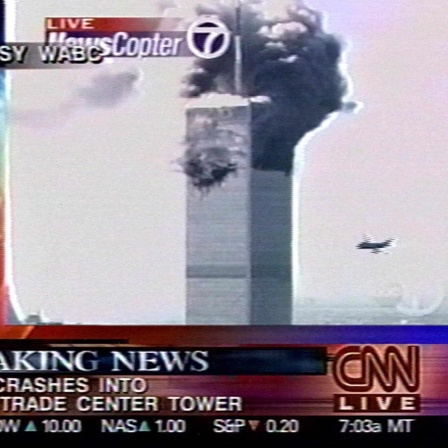 Fernsehbild vom 11. September 2001, das vom WABC-Fernsehen über CNN zur Verfügung gestellt wurde,. Es zeigt ein heranfliegendes Flugzeug, das sich dem World Trade Center in New York nähert, während aus dem Turm bereits Rauch aufstiegt.