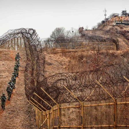 Südkoreanische Soldaten patrouillieren innerhalb der DMZ. Im Hintergrund ein südkoreanischer Wachposten.