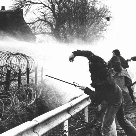 Demonstranten antworten mit Wurfgeschossen auf den Einsatz von Tränengas der Polizei, aufgenommen am 14. November 1976 bei Protestaktionen gegen den geplanten Bau des Atomkraftwerks in Brokdorf im Kreis Steinburg an der Unterelbe. 