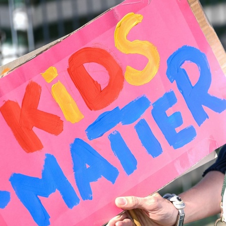 Ein Pappschild bei einer Demo mit der Aufschrift &#034;Kids matter&#034;