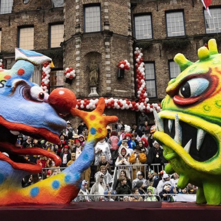 Beim Rosenmontagszug in Düsseldorf zeigt am 24. Februar 2020 ein Bazzillus carneval aus Pappmachée dem Coronavirus eine lange Nase.