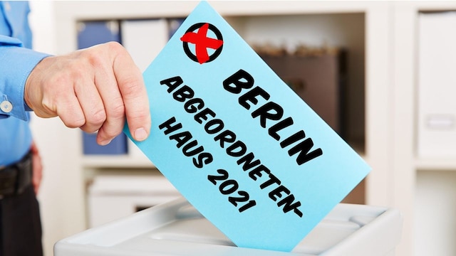 Hand beim Wählen für das Abgeordnetenhaus in Berlin 2021 steckt Stimmzettel in eine Wahlurne (Bild:picture alliance / Zoonar | Robert Kneschke)