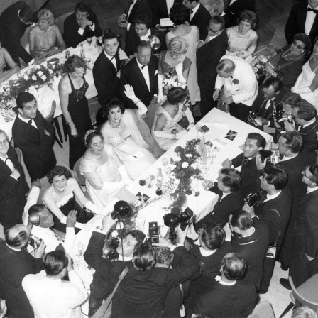 ARCHIV, Berlin, 5. Juli 1958: Die Journalistin Elsa Maxwell (M) und die italienische Schauspielerin Gina Lollobrigida (winkend) auf einem Fest während der Berlinale (Bild: picture-alliance/picture-alliance/dpa/Heinz-Jürgen Göttert)
