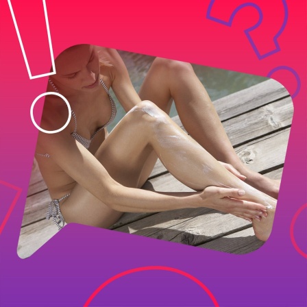 Eine junge Frau cremt sich das Bein mit Sonnencreme ein