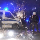 Polizeibeamte stehen in Berlin hinter explodierendem Feuerwerk