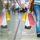 Eine Passantin trägt Einkaufstüten durch ein Einkaufszentrum 