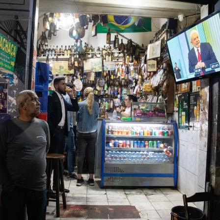 In einer Bar im Stadtviertel Lapa schauen Menschen die letzte TV-Debatte zwischen den beiden Präsidentschaftskandidaten da Silva und Bolsonaro.