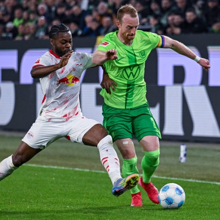 Leipzigs Ridle Baku und Wolfsburgs Maximilian Arnold kämpfen um den Ball