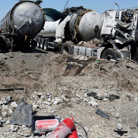 Ein Krater befindet sich nach Beschuss neben zerstörten Lastwagen in der Nähe von Saporischschja in Rosumiwka (Ukraine).