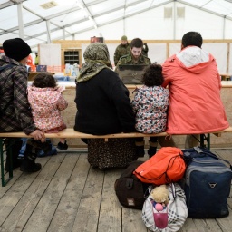 Syrische Flüchtlinge werden im Wartezentrum für Flüchtlinge beim Fliegerhorst in Erding (Bayern) von einem Bundeswehrsoldaten registriert. 