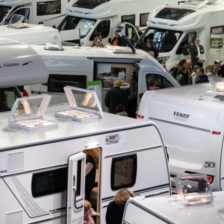 Besucher gehen auf der Urlaubsmesse Caravan Motor Touristik (CMT) in einer Halle der Messe Stuttgart zwischen Reisemobilen und Wohnwägen entlang.
