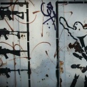 Motive des Berliner Street-Art-Künstlers Emess zum Thema Krieg und Frieden auf einer alten Eisentür auf einer Industriebrache, aufgenommen in Berlin im Bezirk Kreuzberg am 03.04.2014. Berlin ist ein Zentrum für Street Art, das Künstler aus dem In- und Ausland anzieht.