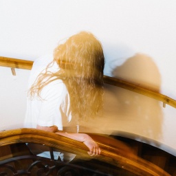 Blonde Frau im Treppenhaus mit Schatten an der Wand