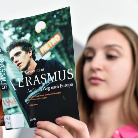 Eine Studentin liest in einem Buch über das Erasmus-Programm