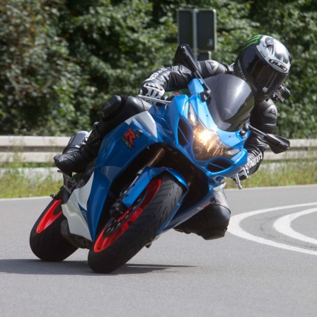 Symbolbild: Motorradfahrer:in fährt eine kurvige Straße