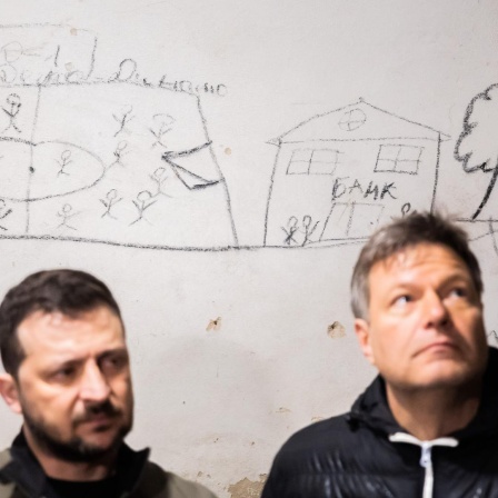 Robert Habeck (Bündnis 90/Die Grünen, r), Bundesminister für Wirtschaft und Klimaschutz, und Wolodymyr Selenskyj, Präsident der Ukraine, stehen nordöstlich von Kiew in einem Schulkeller, in dem Geiseln gehalten wurden vor einer Wand mit Bildern der Gefangenen. 